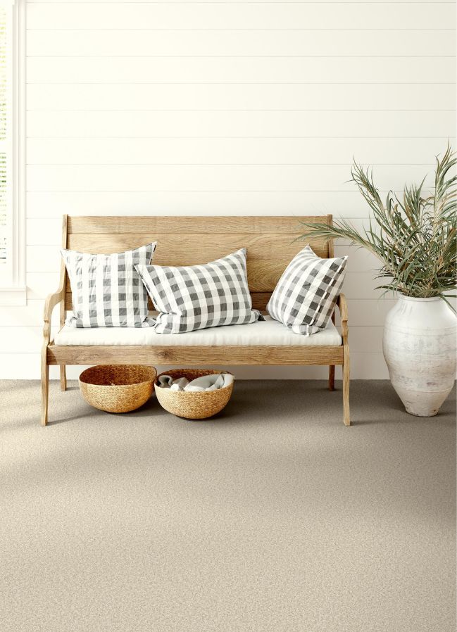 beige carpets in a bright entryway with bench